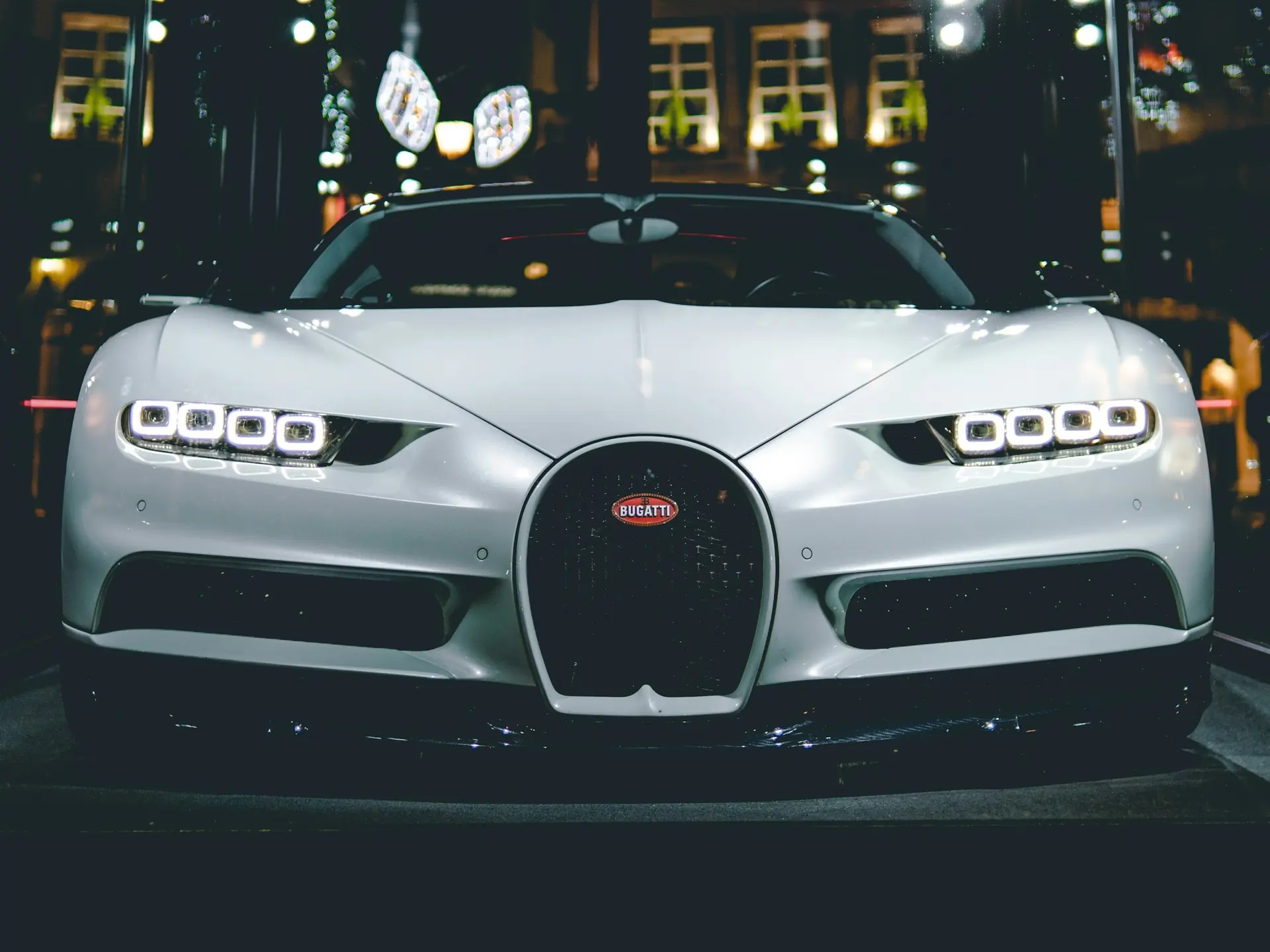 A white Bugatti Chiron front-on at night in the city