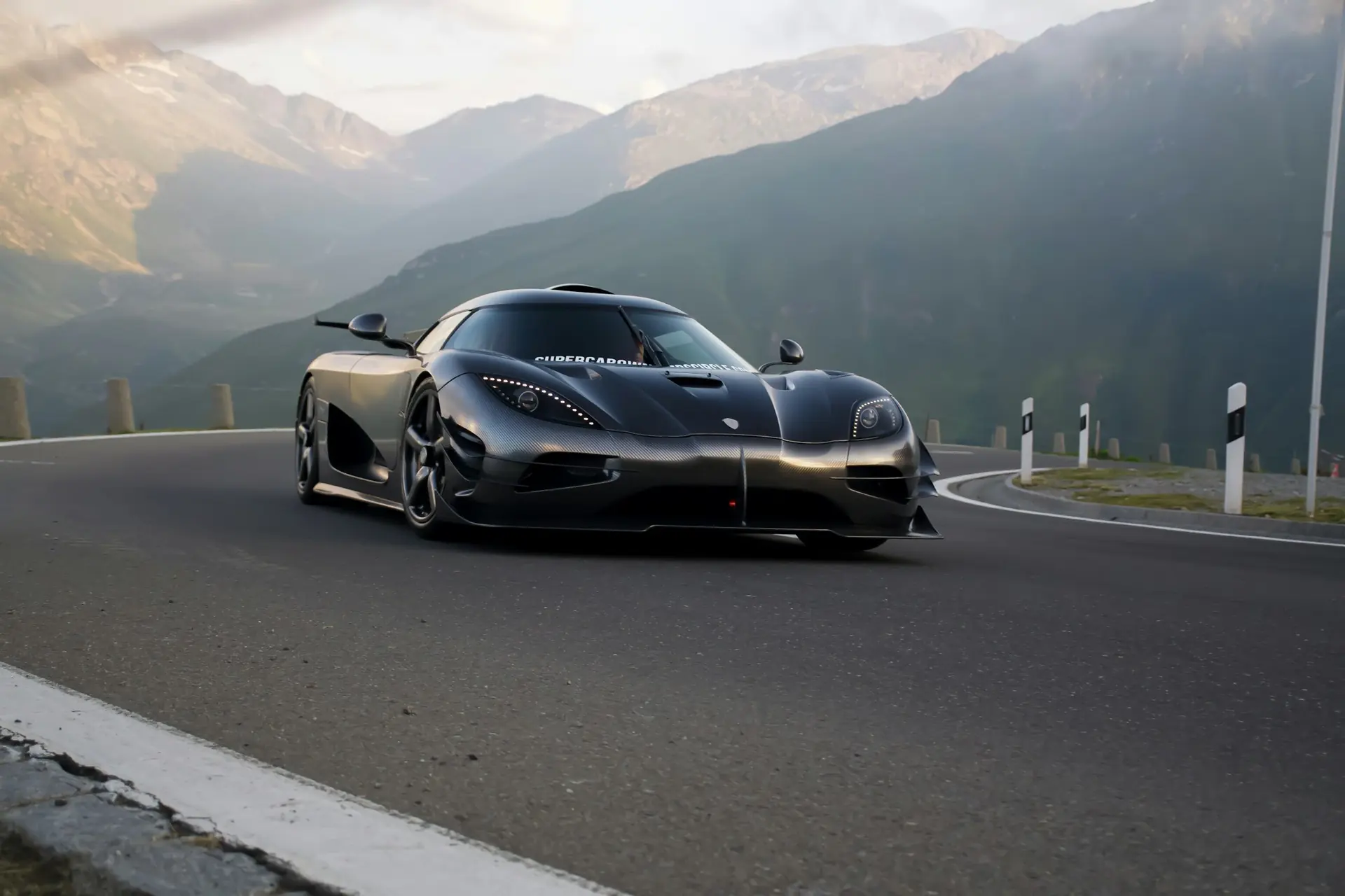 A dark Koenigsegg Agera on a mountain pass