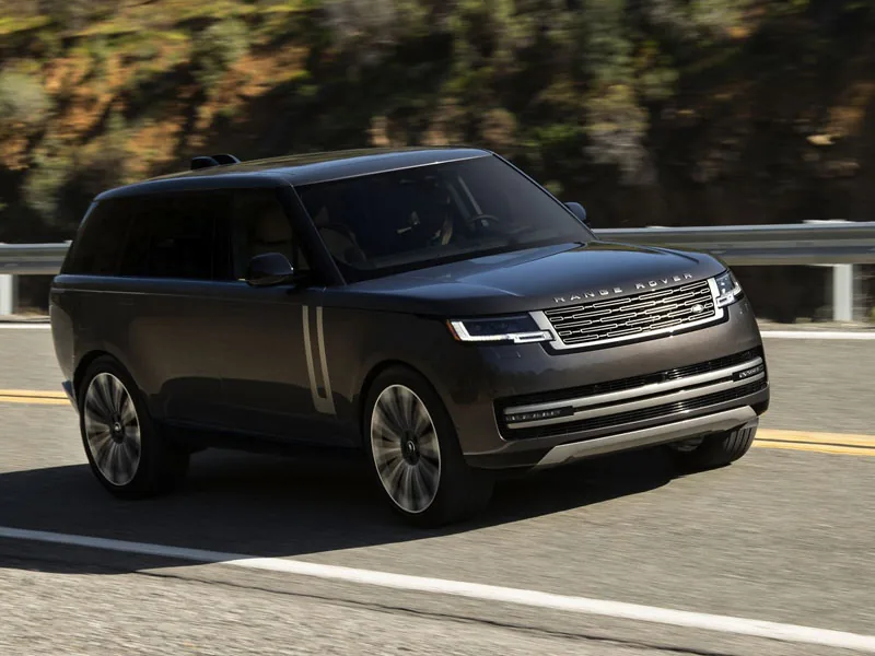 A bronze Range Rover on a coastal road